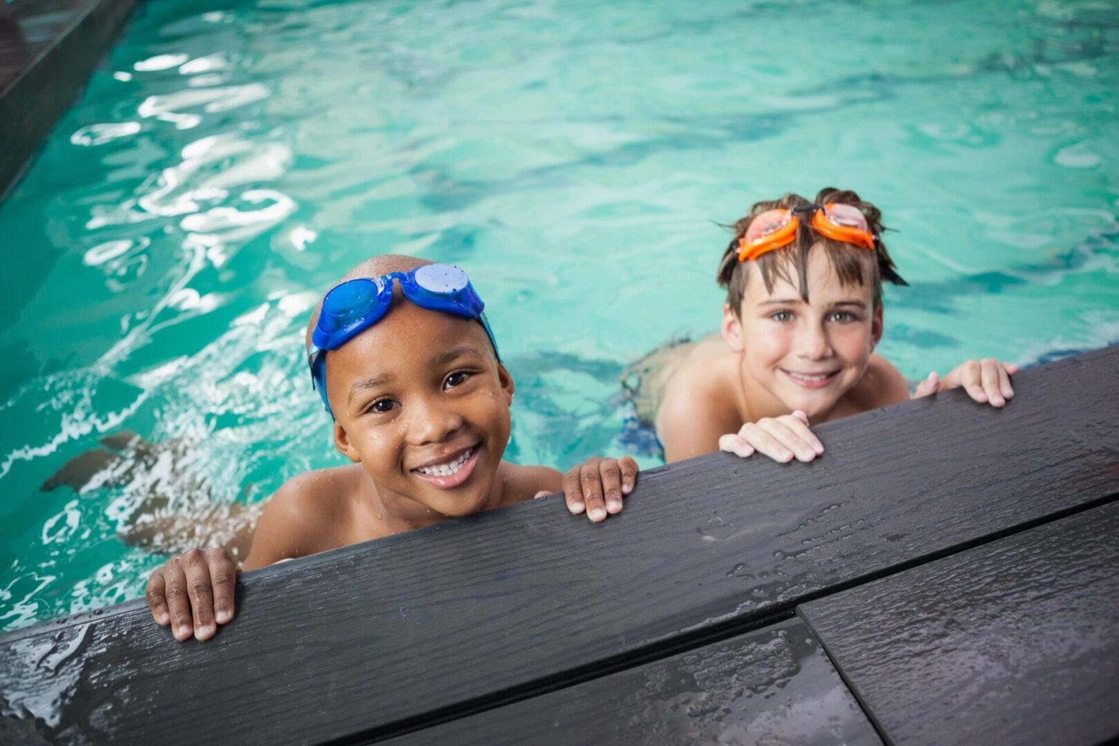 Two children in the pool with goggles on